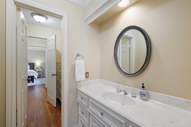 bathroom featuring a textured ceiling, wood-type flooring, and vanity