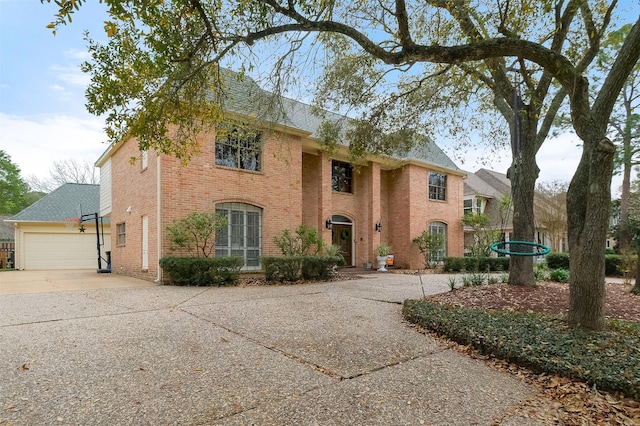 view of front of home featuring a garage, driveway, brick siding, and roof with shingles