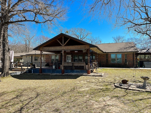 rear view of house with a yard and brick siding