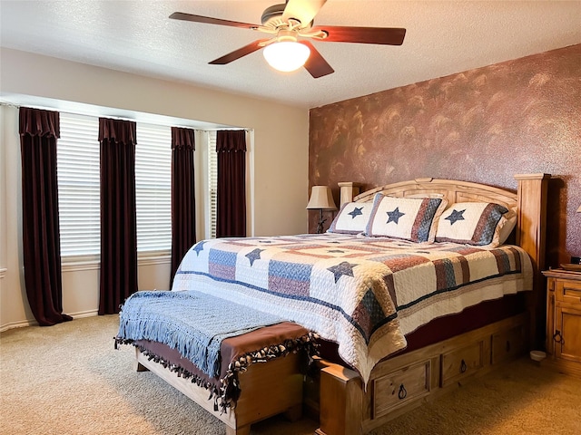 carpeted bedroom featuring baseboards, wallpapered walls, ceiling fan, a textured ceiling, and an accent wall