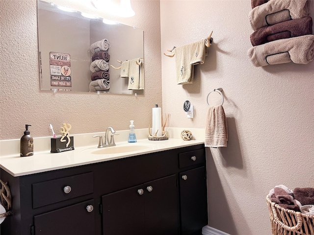 bathroom with vanity and a textured wall