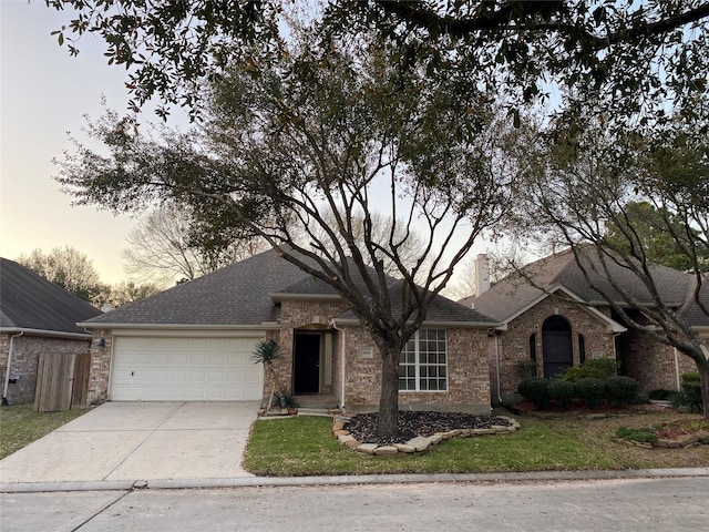 ranch-style house featuring an attached garage, brick siding, driveway, and a chimney