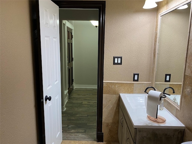 bathroom with vanity, tile walls, and a textured wall