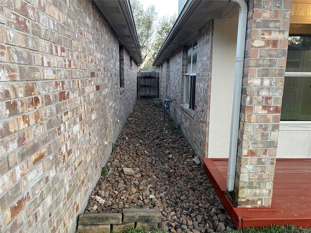 view of side of home featuring a garage and brick siding