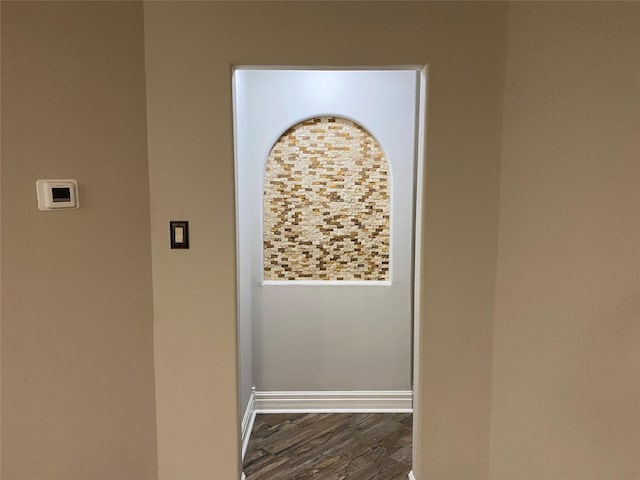 hallway with dark wood finished floors and baseboards