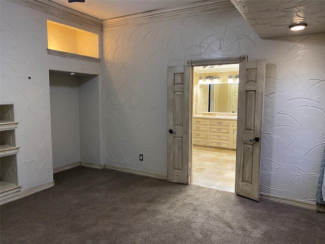 spare room with ornamental molding, a textured ceiling, baseboards, and carpet floors