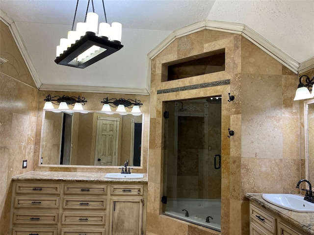 bathroom featuring a shower stall, vanity, lofted ceiling, ornamental molding, and tile walls