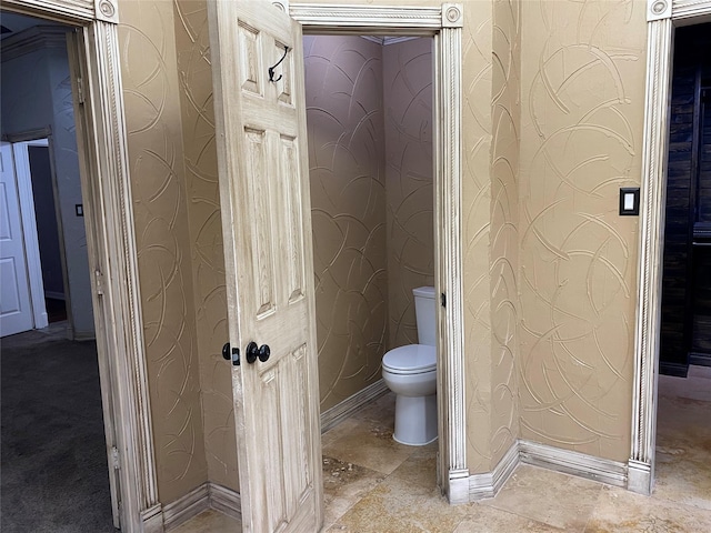 bathroom featuring toilet and baseboards