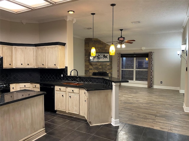 kitchen featuring a sink, black dishwasher, dark countertops, and a peninsula