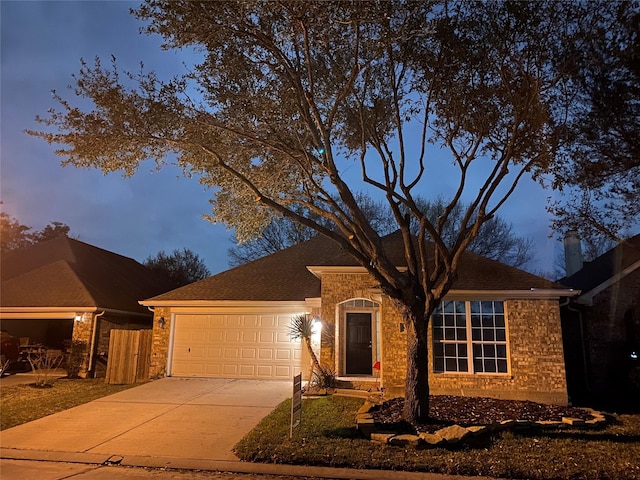 ranch-style house with concrete driveway, a garage, and a shingled roof