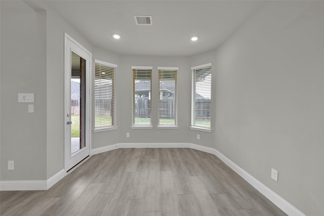 spare room with recessed lighting, visible vents, baseboards, and wood finished floors