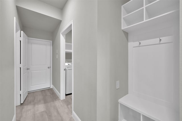 mudroom featuring washer / dryer, baseboards, and light wood finished floors