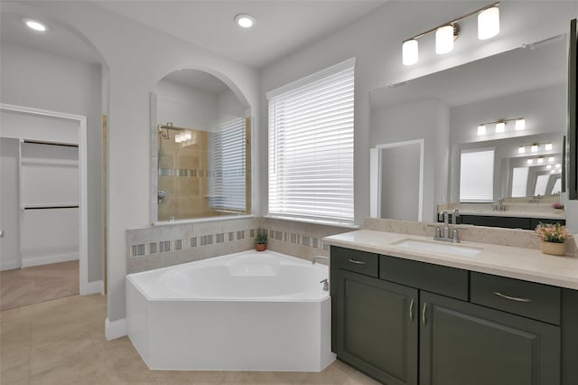 bathroom with a garden tub, recessed lighting, a tile shower, vanity, and tile patterned flooring