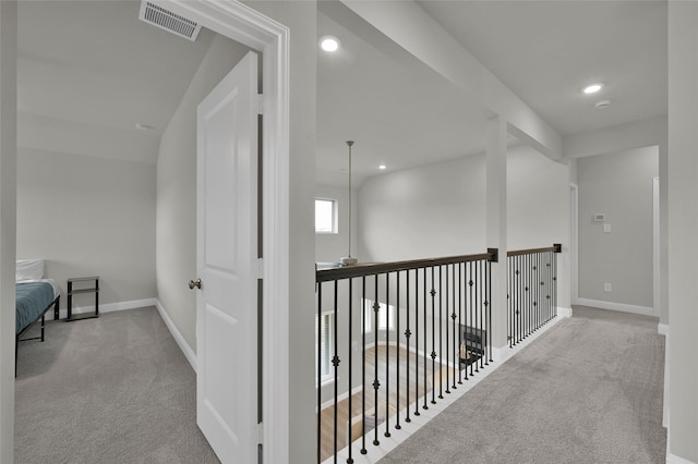 hallway with carpet flooring, visible vents, and baseboards