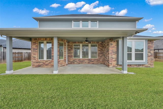 back of house featuring a patio area, a yard, fence, and brick siding