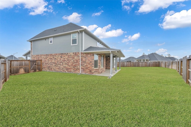 back of house featuring a fenced backyard, a patio, a lawn, and brick siding