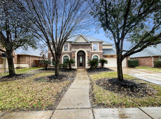 traditional-style house featuring an attached garage, concrete driveway, and brick siding