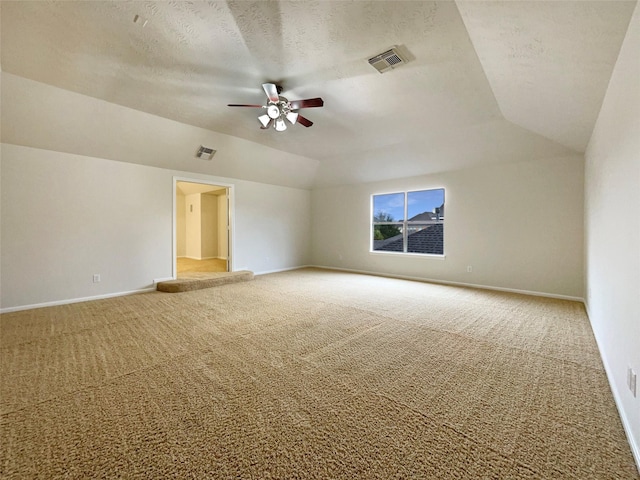 unfurnished room with vaulted ceiling, a ceiling fan, visible vents, and light colored carpet