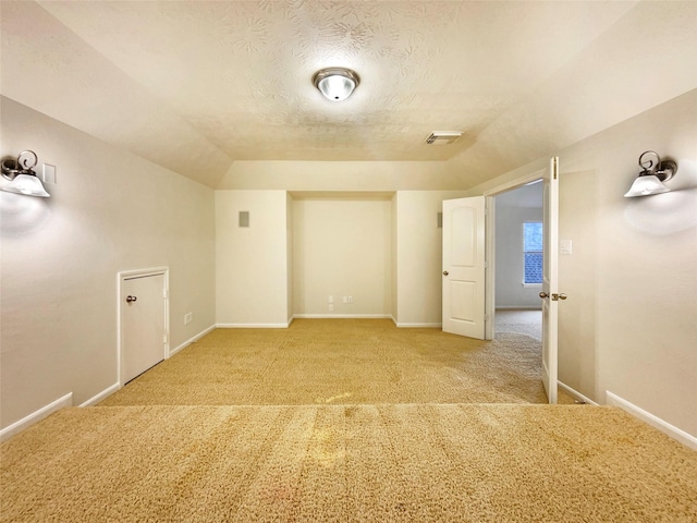 bonus room with light carpet, baseboards, visible vents, vaulted ceiling, and a textured ceiling