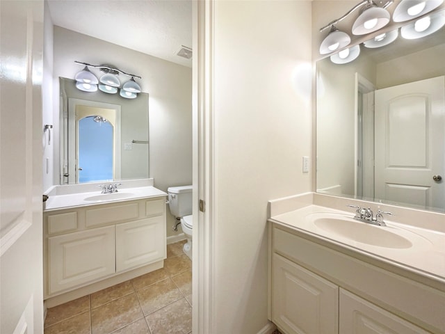 bathroom with tile patterned flooring, visible vents, vanity, and toilet