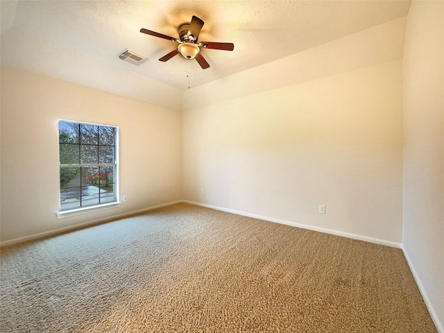 spare room featuring baseboards, visible vents, ceiling fan, vaulted ceiling, and carpet flooring