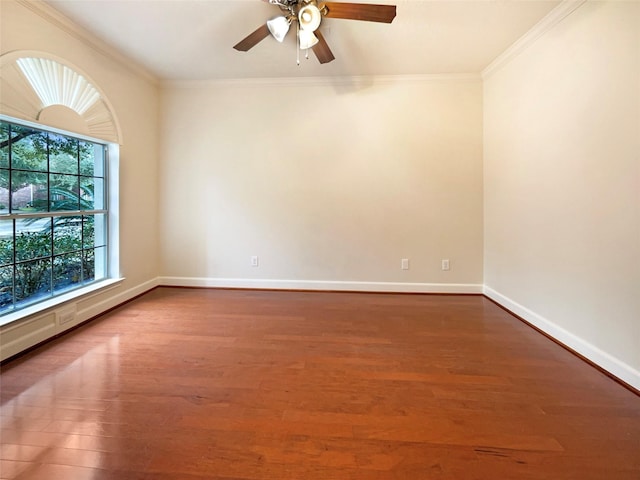 spare room featuring crown molding, baseboards, and wood finished floors