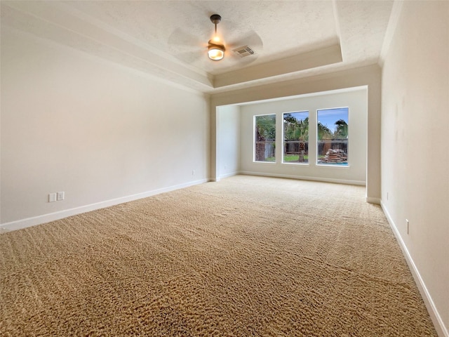 spare room with a raised ceiling, visible vents, a textured ceiling, and carpet flooring