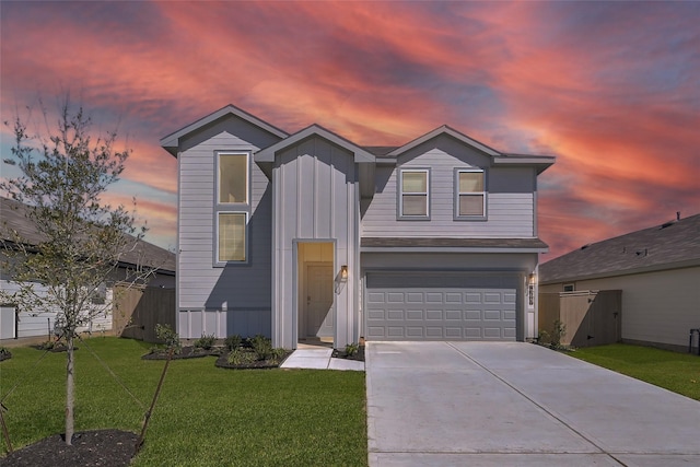 view of front facade featuring concrete driveway, an attached garage, fence, board and batten siding, and a front yard