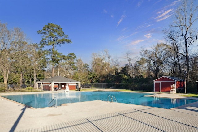 546 River Plantation Dr, Conroe, TX 77302 - community pool with a patio, view of scattered trees, and an outdoor structure