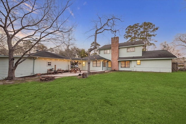 546 River Plantation Dr, Conroe, TX 77302 - rear view of house with a chimney, a patio area, and a lawn