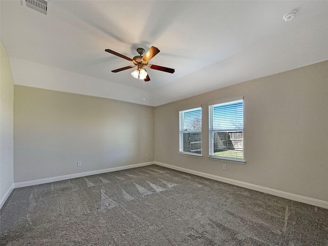 unfurnished room featuring visible vents, dark carpet, baseboards, and ceiling fan