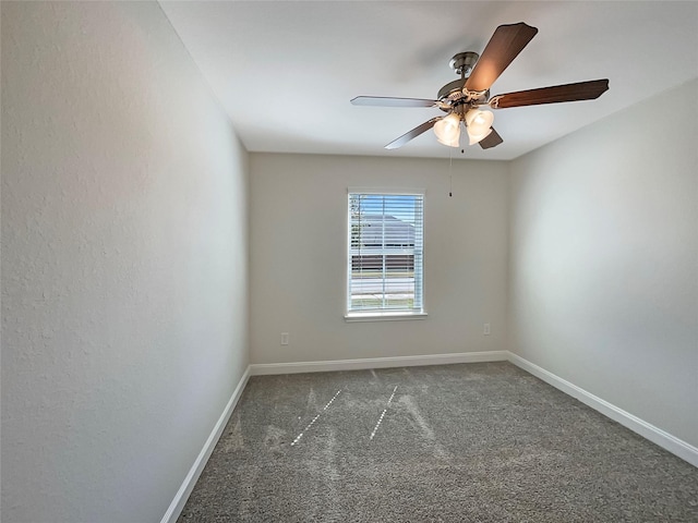 carpeted spare room with baseboards and a ceiling fan