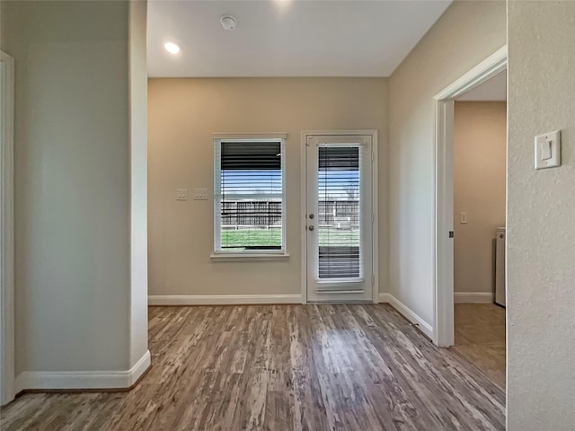 doorway to outside featuring baseboards and wood finished floors