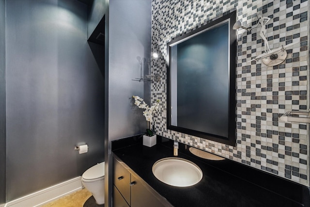 bathroom featuring toilet, tile patterned flooring, baseboards, and vanity