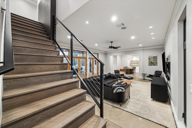 living area with visible vents, crown molding, and stairs