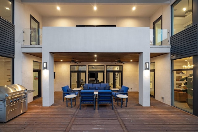 wooden terrace with an outdoor hangout area, area for grilling, and a ceiling fan