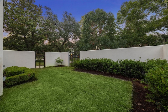 view of yard with a fenced front yard and a gate