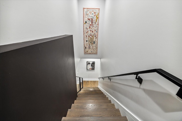 stairway featuring baseboards and wood finished floors