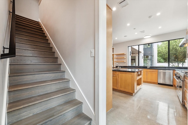 stairs featuring finished concrete floors, recessed lighting, and visible vents