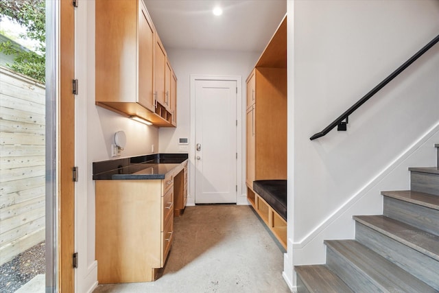 bar featuring concrete flooring and stairway