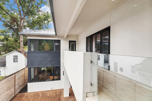 exterior space with metal roof, a balcony, and stucco siding