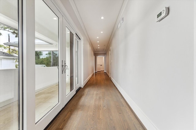 hall with baseboards, french doors, wood finished floors, and crown molding