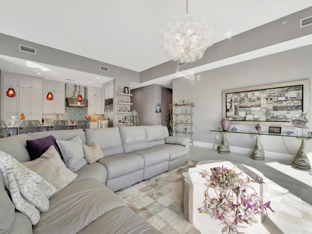 living room with an inviting chandelier, baseboards, visible vents, and recessed lighting