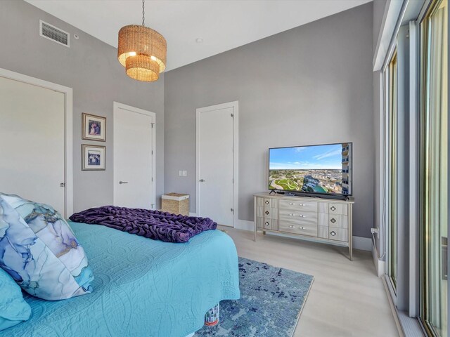 bedroom featuring a towering ceiling and visible vents