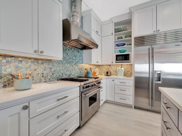 kitchen featuring open shelves, light countertops, backsplash, white cabinets, and built in appliances