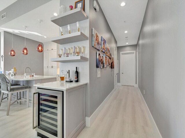 bar featuring wine cooler, recessed lighting, visible vents, wet bar, and baseboards