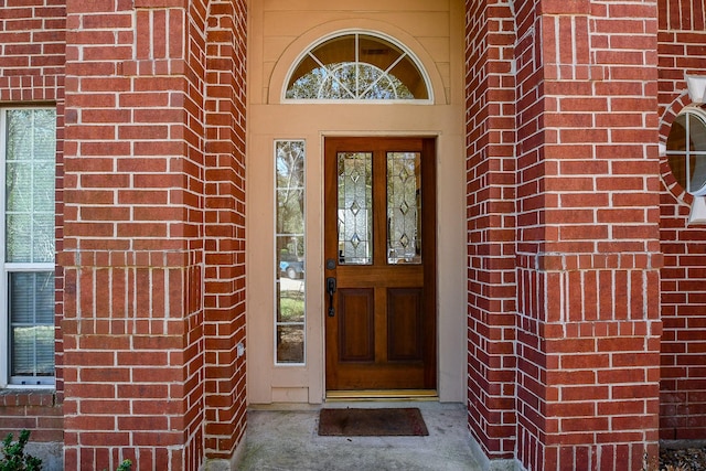 property entrance featuring brick siding