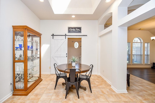 dining space with recessed lighting, light tile patterned flooring, and a barn door