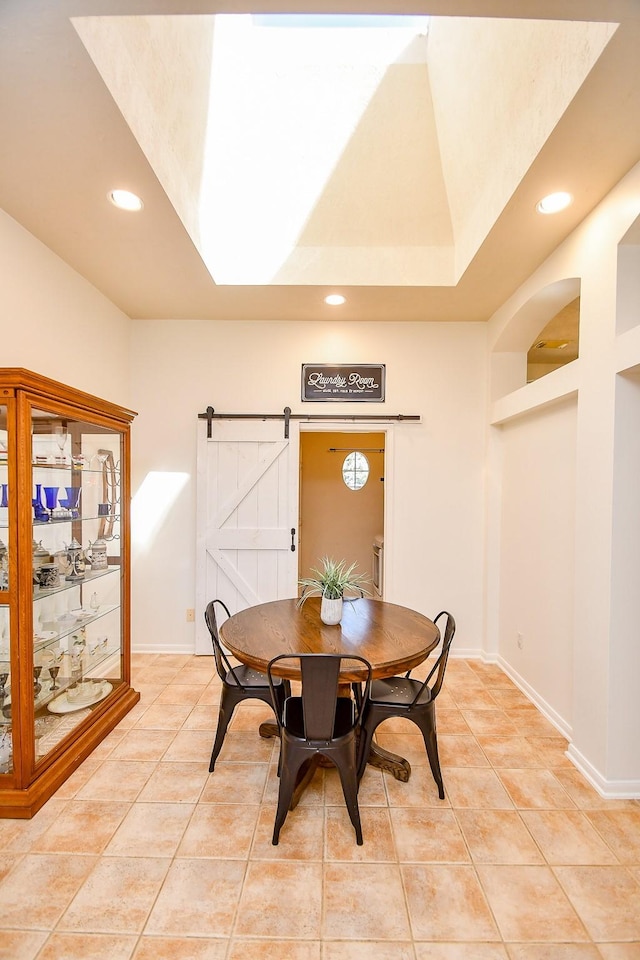 dining space featuring light tile patterned floors, a barn door, baseboards, and recessed lighting