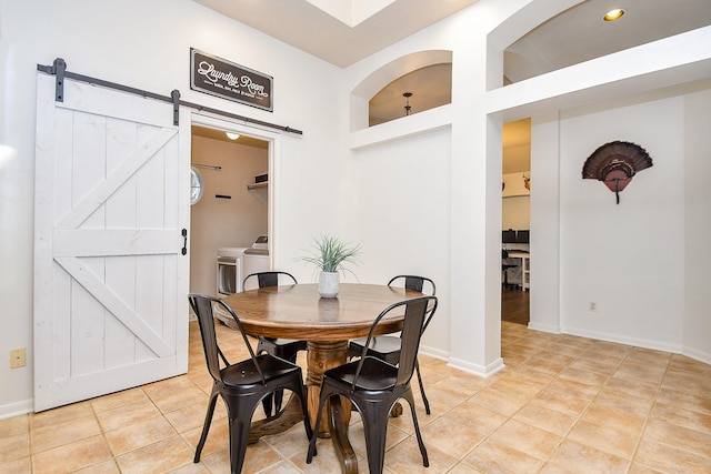 dining space featuring built in shelves, light tile patterned floors, baseboards, and a barn door